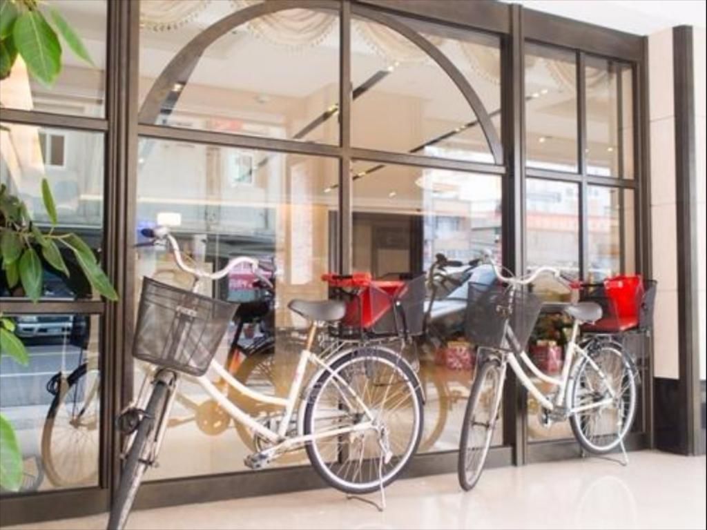 Una bicicleta estacionada frente a un edificio con amplias ventanas de vidrio.