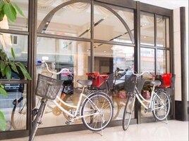 Una bicicleta estacionada frente a un edificio con amplias ventanas de vidrio.