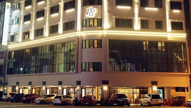 A multi-story hotel with illuminated signage and a modern facade. - Grand Earl Hotel (Douliou)