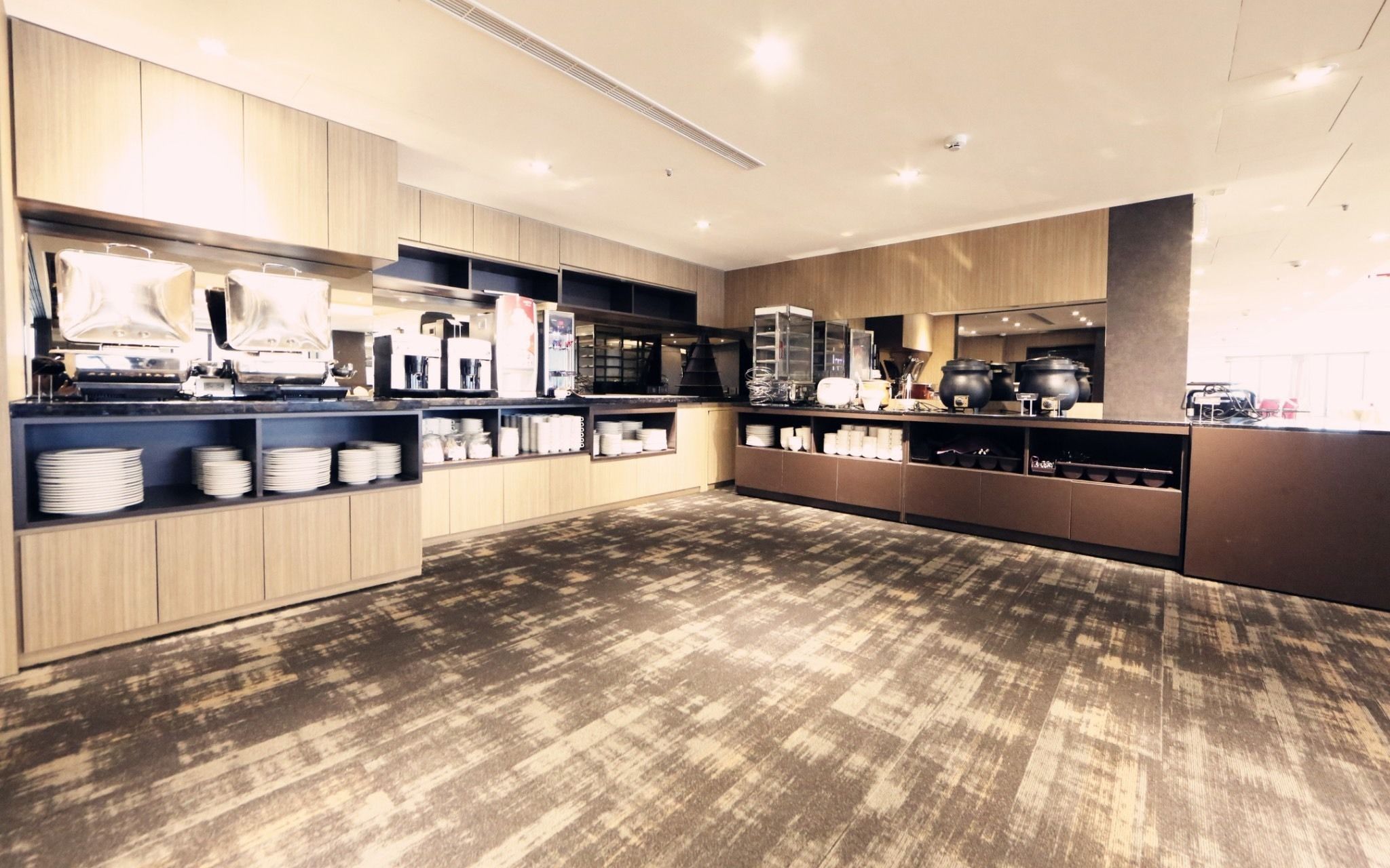 Une cuisine moderne avec des meubles en bois, un îlot central et divers appareils de cuisine.