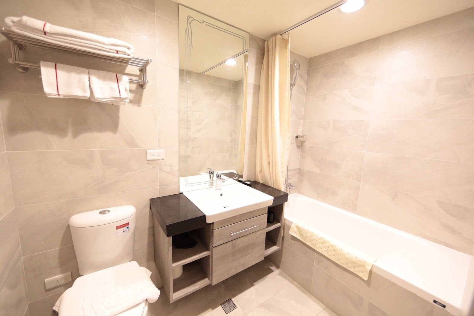 A modern bathroom with a toilet, sink, and bathtub.