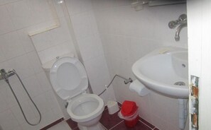 A small bathroom with a toilet, a sink, and a shower. - Red Rose Hotel (Fethiye)