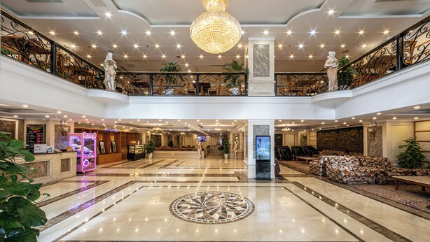 A spacious lobby with a central decorative floor pattern, a chandelier, and a reception desk. - A25 Signature Hotel (Hanoi)