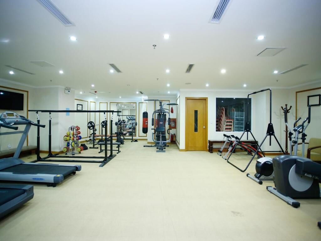 Academia com esteiras, máquinas de peso e equipamentos de ginástica.