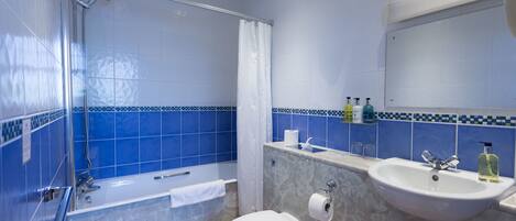 A bathroom with a bathtub, toilet, sink, and shower.