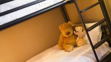 Een stapelbed met twee teddyberen op het onderste bed.