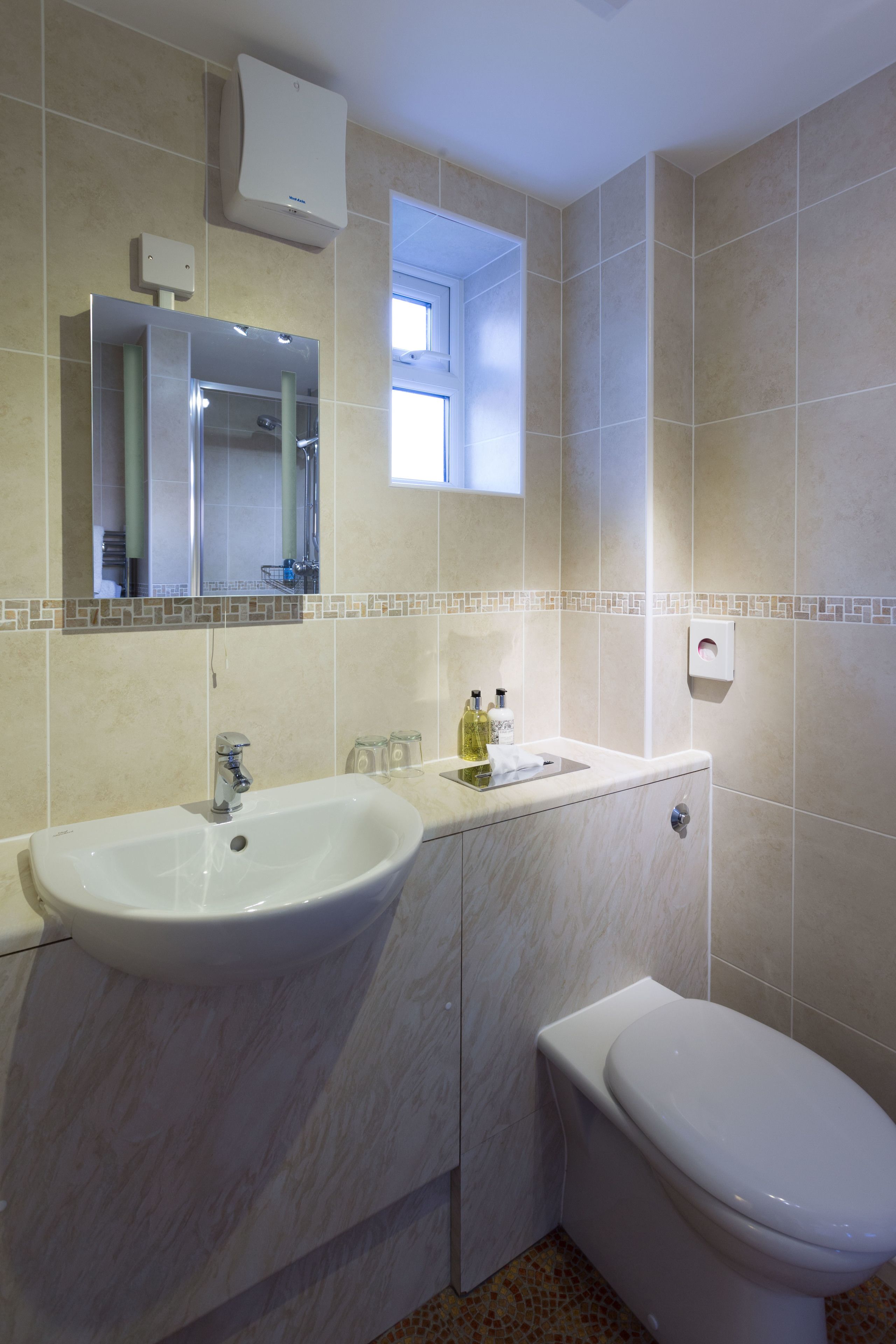 A bathroom with a sink, mirror, and toilet.