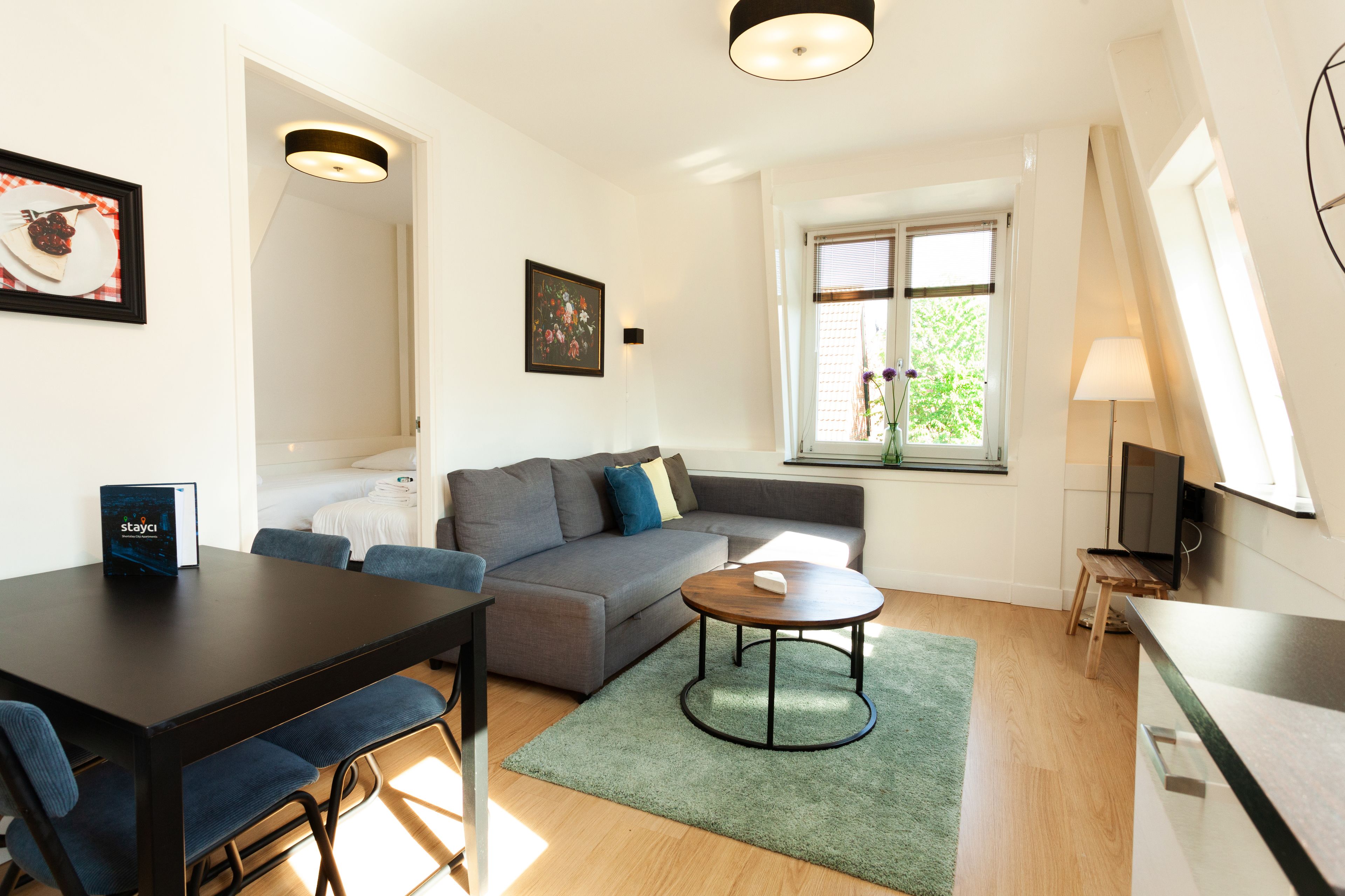 Una sala moderna con sofá, mesa de comedor y televisor.