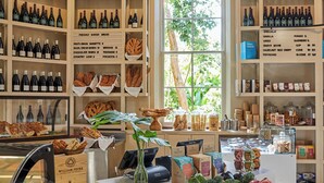 A bakery with shelves of bread and pastries, a display of wine bottles, and a variety of packaged goods. - The Island House (Nassau)