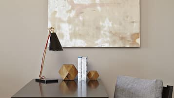 A modern room with a desk, chair, and a large abstract painting on the wall.