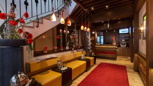 A hotel lobby with a reception desk, seating area, and a staircase. - Hotel Zum Rosengarten (Darmstadt)