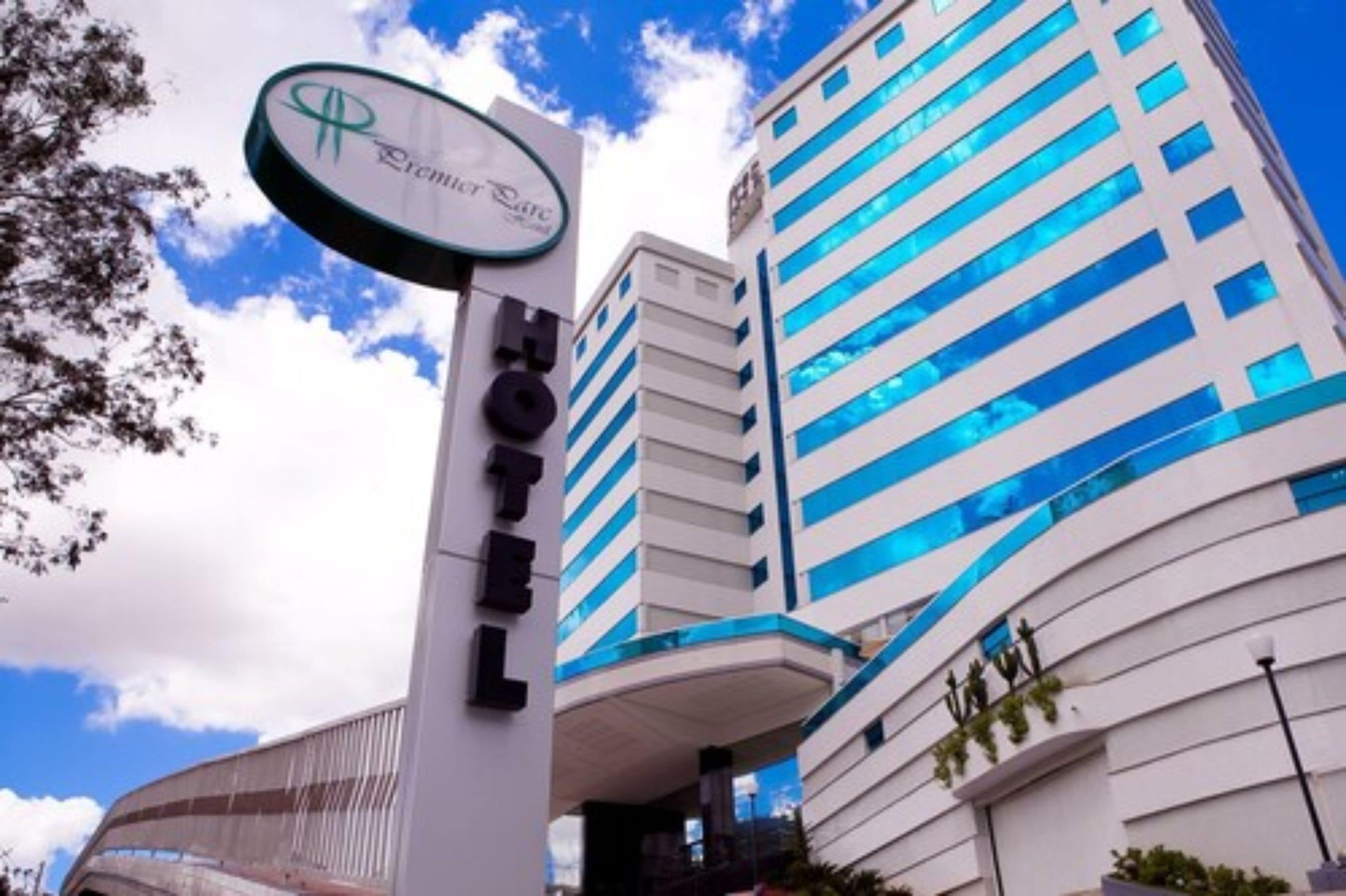 Un hotel con un letrero llamativo, arquitectura moderna y cielo despejado.