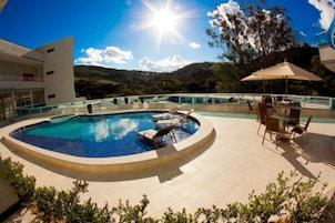 Una piscina al aire libre, sillones reclinables de piscina