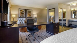 A hotel room with a large bed, a desk with a chair, a TV, and two framed pictures on the wall. - Hampton Inn & Suites Columbus (Columbus)