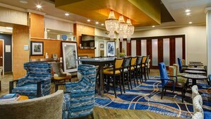 A hotel lobby with a bar area, seating arrangements, and a television. - Hampton Inn & Suites Columbus (Columbus)