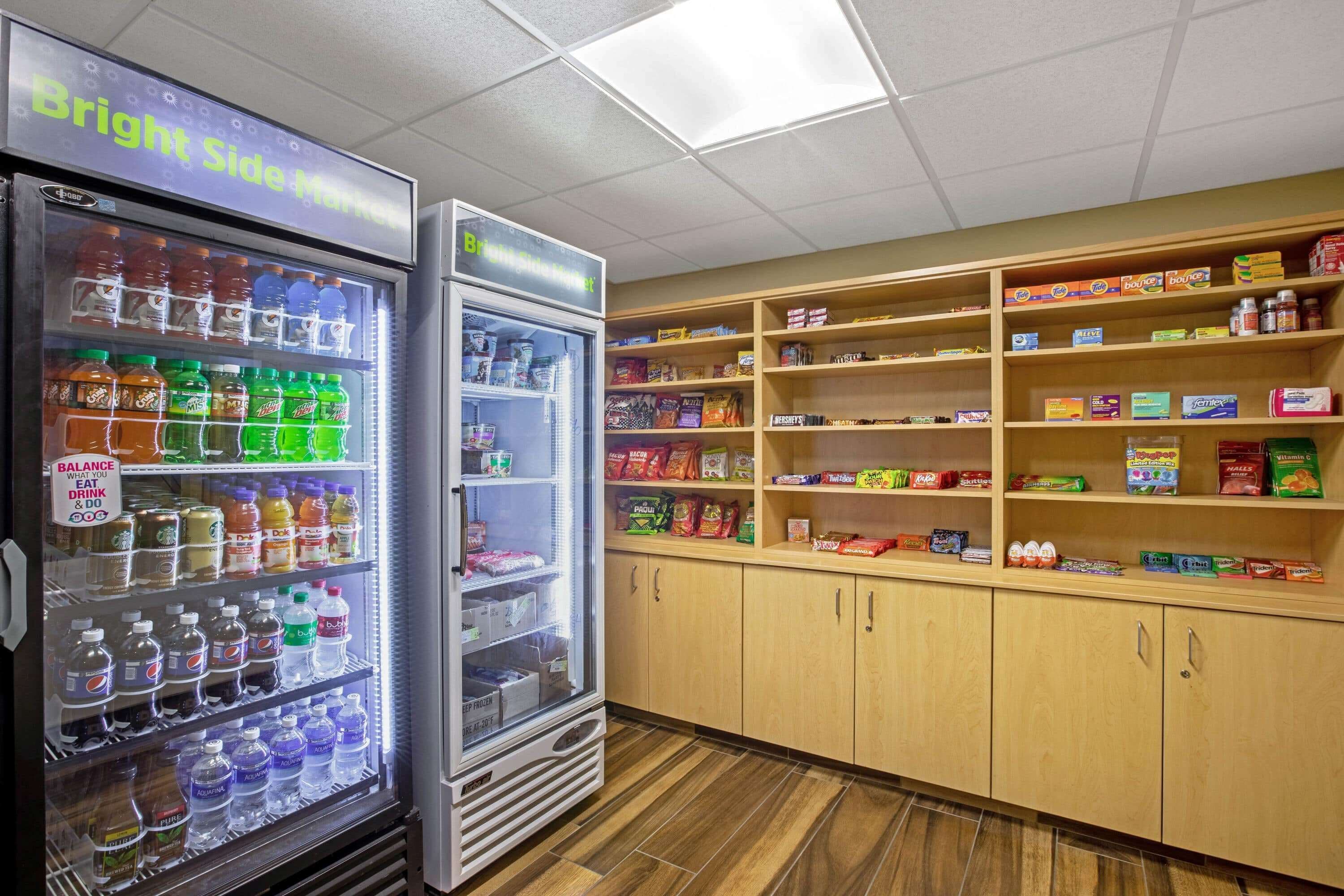 Ein Warenautomat mit Getränken und Snacks, sowie Regale mit verpackten Lebensmitteln.