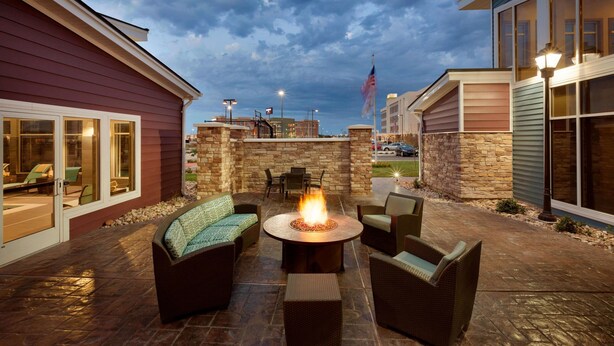 An outdoor patio with a fire pit, seating, and stone walls. - Residence Inn by Marriott San Angelo (San Angelo)
