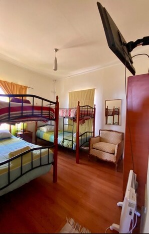 A room with bunk beds, a chair, a desk, and a ceiling fan. - Casa Ferrari 406 (Valparaiso)
