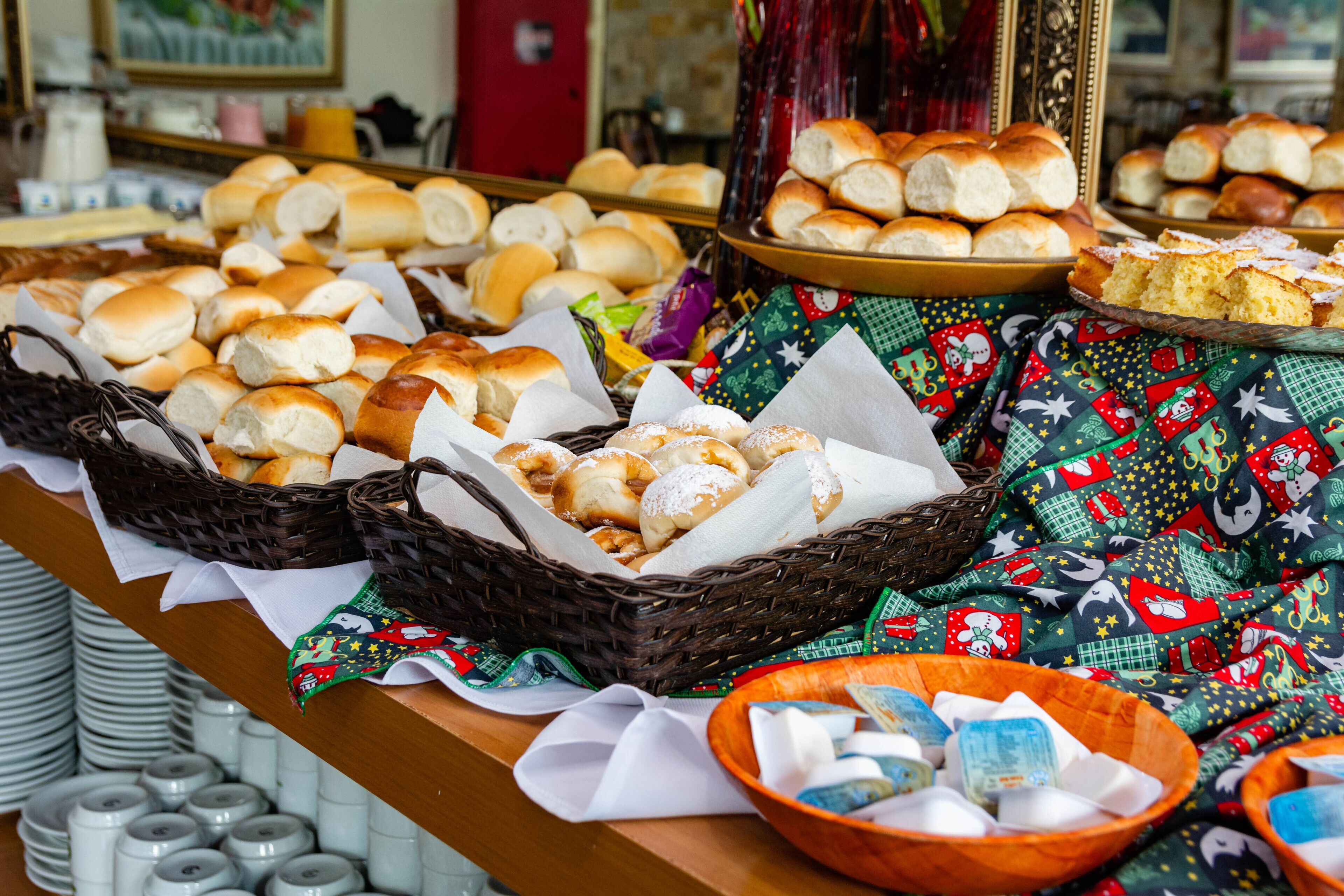 A buffet table with various baked goods and a festive tablecloth.