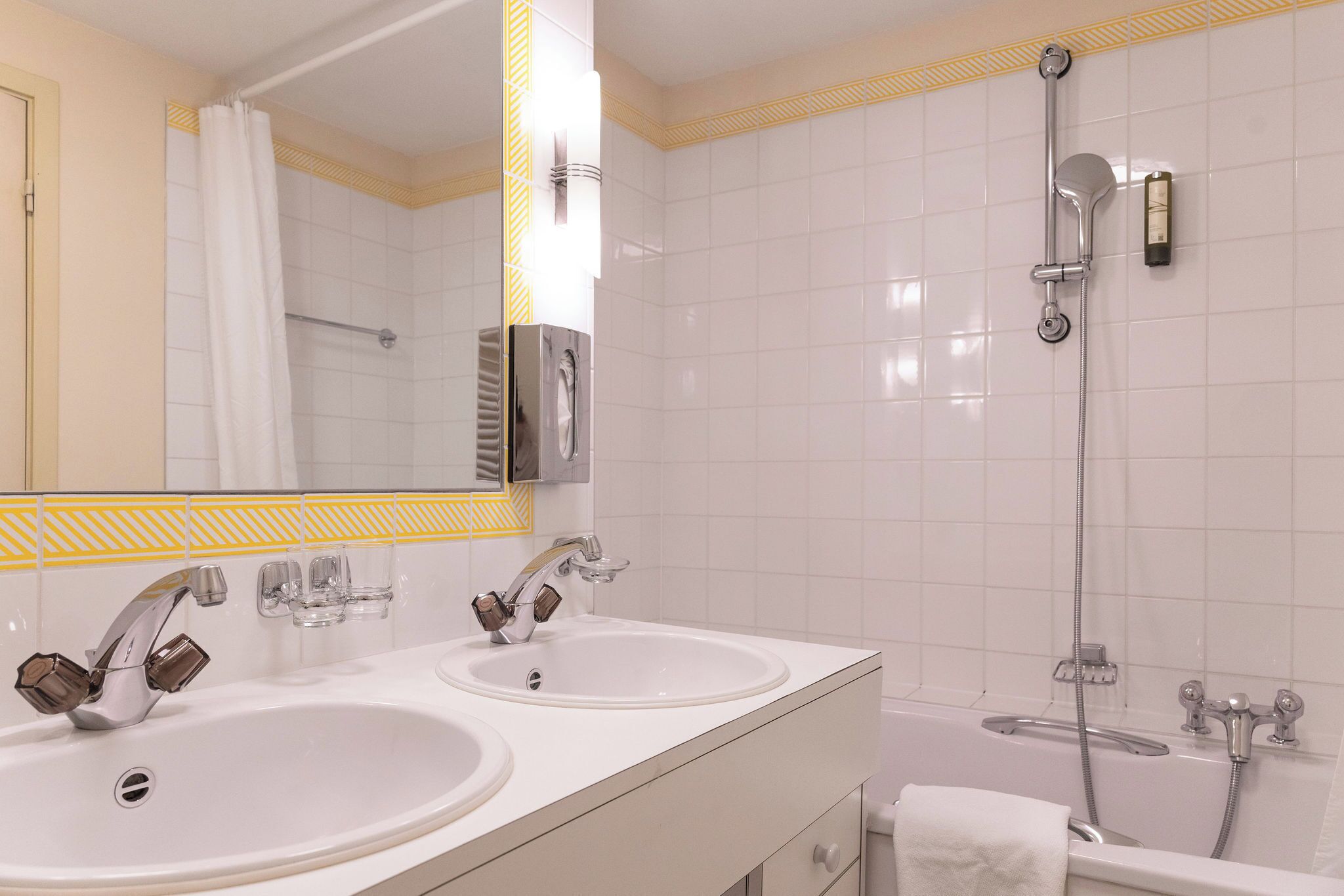 A bathroom with two sinks, a shower, and a bathtub.