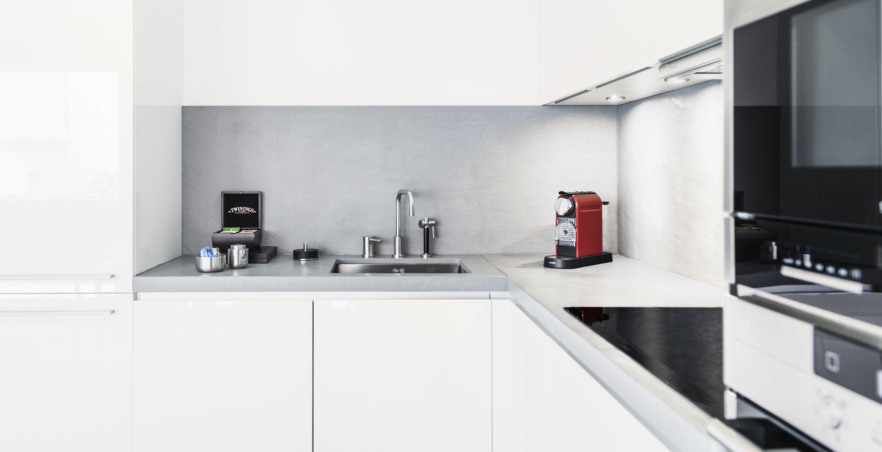 A modern kitchen with a built-in dishwasher, a coffee machine, and a microwave.