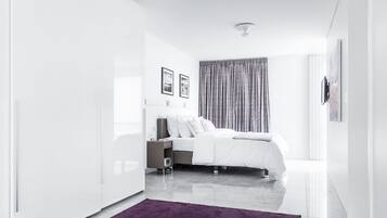 Une chambre moderne avec un lit, une table de chevet et une grande fenêtre avec des rideaux.