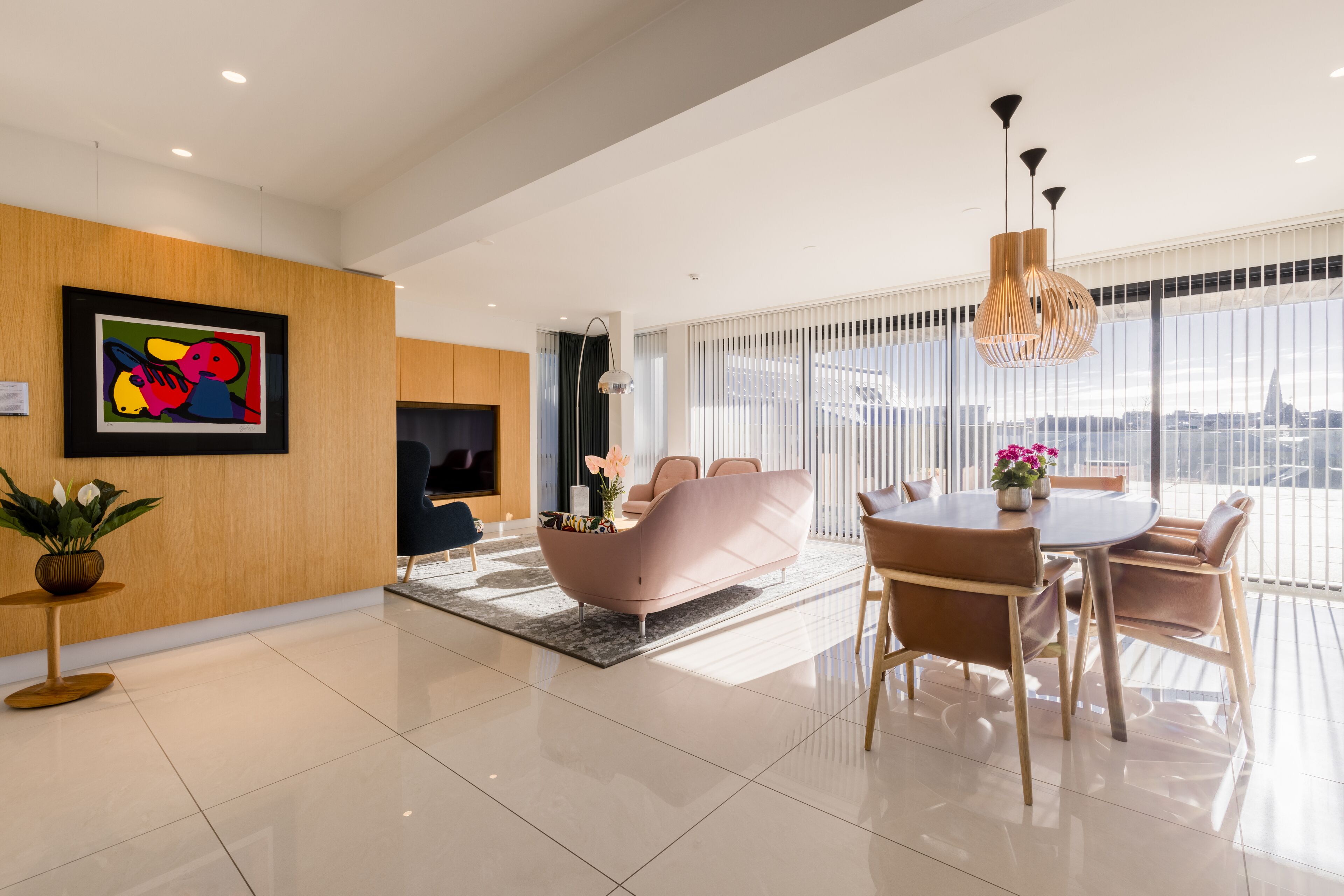 A modern living room with a sofa, a dining table, and a TV.