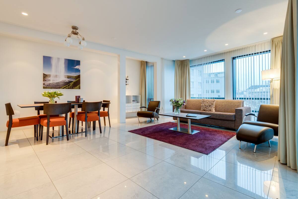 Una sala de estar moderna con comedor, un sofá y una mesa de centro.