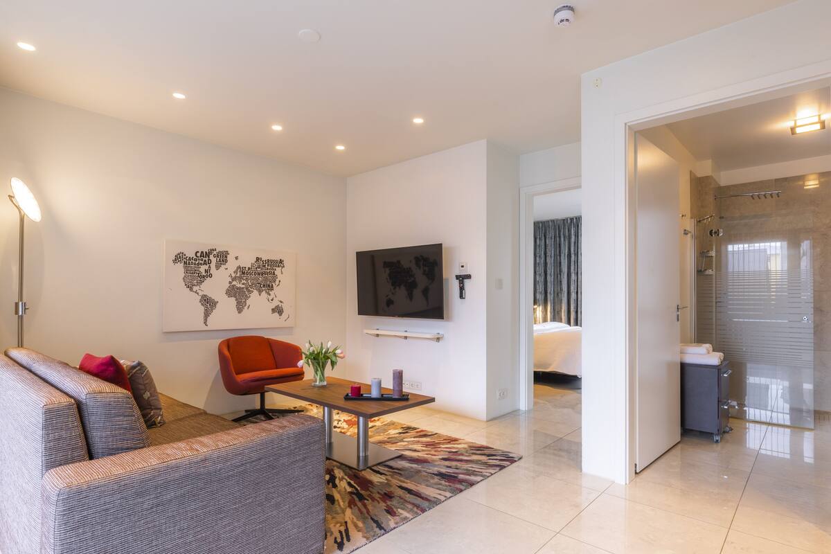 Una sala de estar moderna con un sofá, una mesa de centro y un mapa mundial en la pared.
