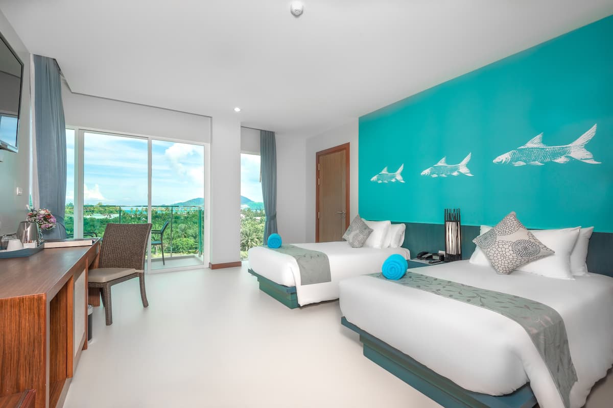 A modern hotel room with two beds, a desk, and a view of the outdoors.
