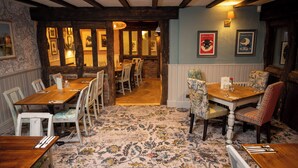 A dining area with wooden tables and chairs, a patterned carpet, and framed pictures on the walls. - Berkshire Arms by Chef and Brewer Collection (Reading)