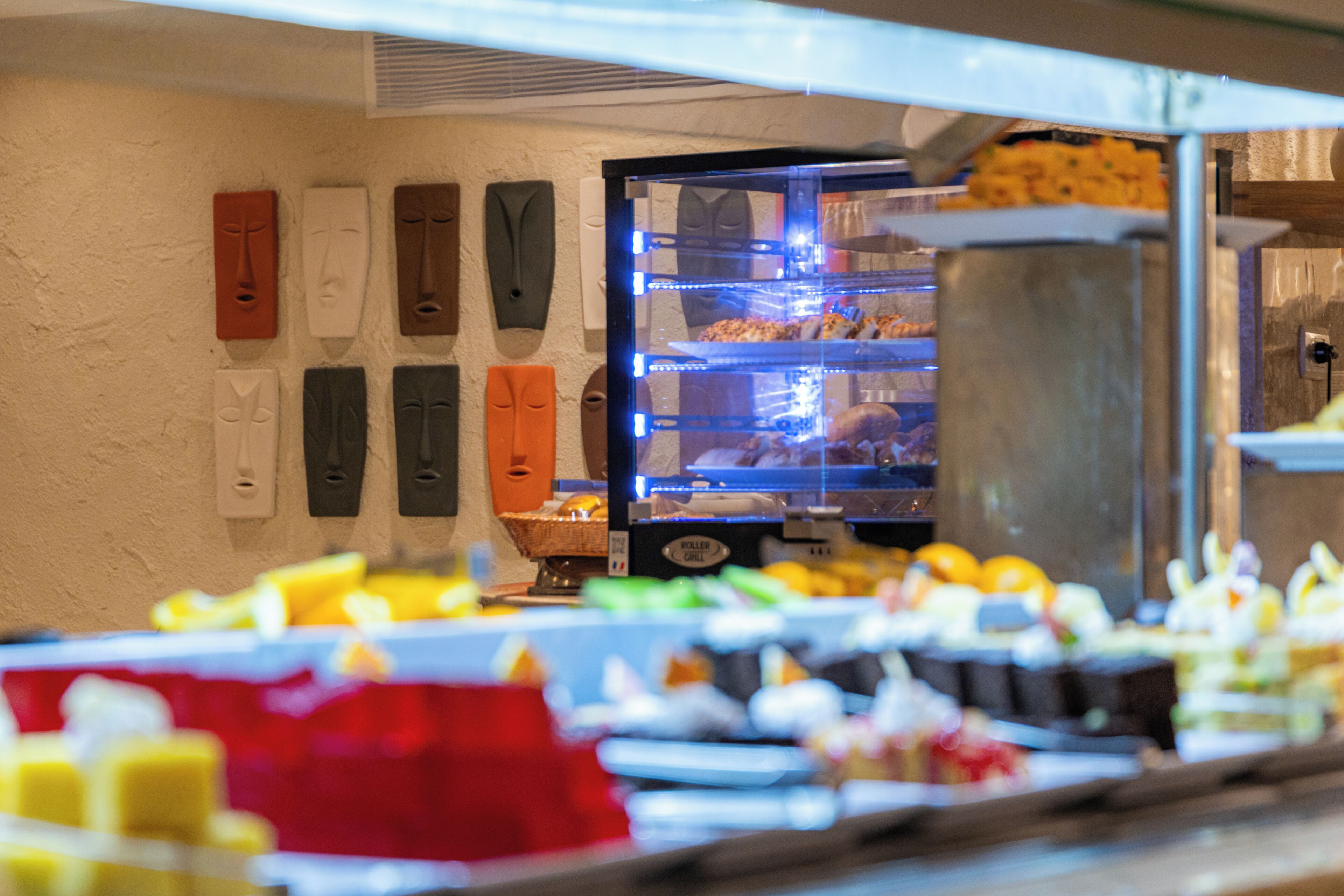 A buffet with various food items and a refrigerator with beverages.