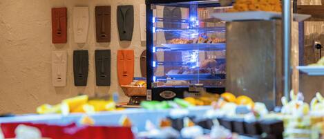A buffet with various food items and a refrigerator with beverages.
