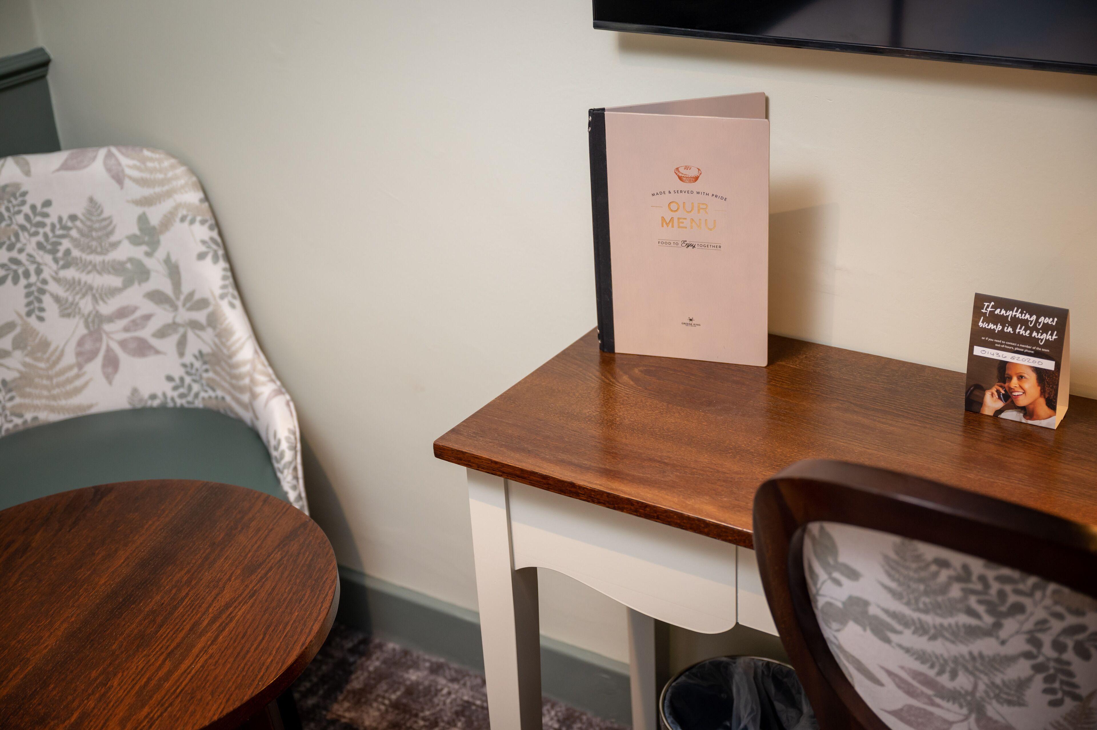 A wooden table with a menu and a sign with a quote.