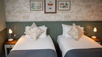 A double bed room with two nightstands, each with a lamp, and three framed butterfly prints on the wall.