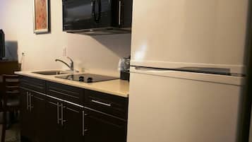 Una cocina equipada con microondas, estufa, fregadero y refrigerador.