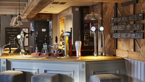 A bar area with multiple taps, including Guinness and IPA, and a sign encouraging to try real ales. - Cross Keys Hotel by Chef and Brewer Collection (Guisborough)