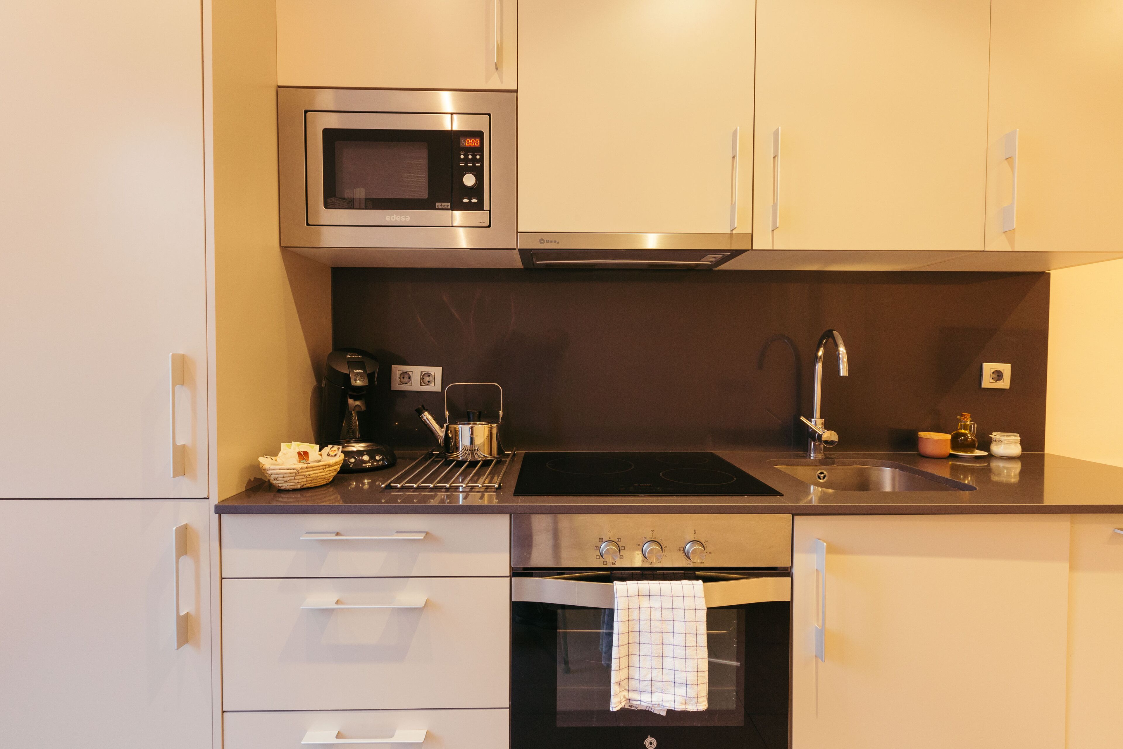 A modern kitchen with stainless steel appliances, a sink, and a built-in oven.