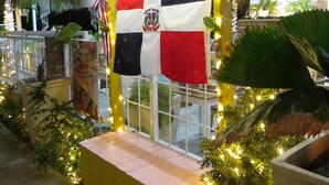 A restaurant with a thatched roof, a flag, and string lights. - Punta Cana Hostel (Punta Cana)