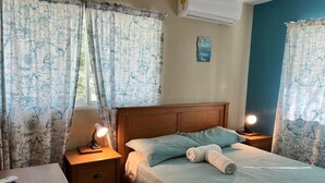 A bedroom with a bed, bedside tables, a lamp, and curtains. - Punta Cana Hostel (Punta Cana)