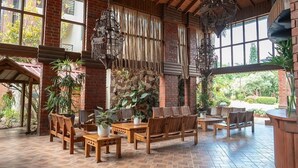 A spacious patio area with wooden furniture, potted plants, and hanging lanterns. - Hotel Gran Jimenoa (Jarabacoa)