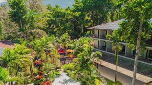 A resort with a central courtyard, palm trees, and a building with a tiled roof. - Hotel Gran Jimenoa (Jarabacoa)