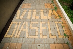 A paved pathway with a 'WASH' sign painted in a maze pattern. - Villa Diasselo (Hersonissos)