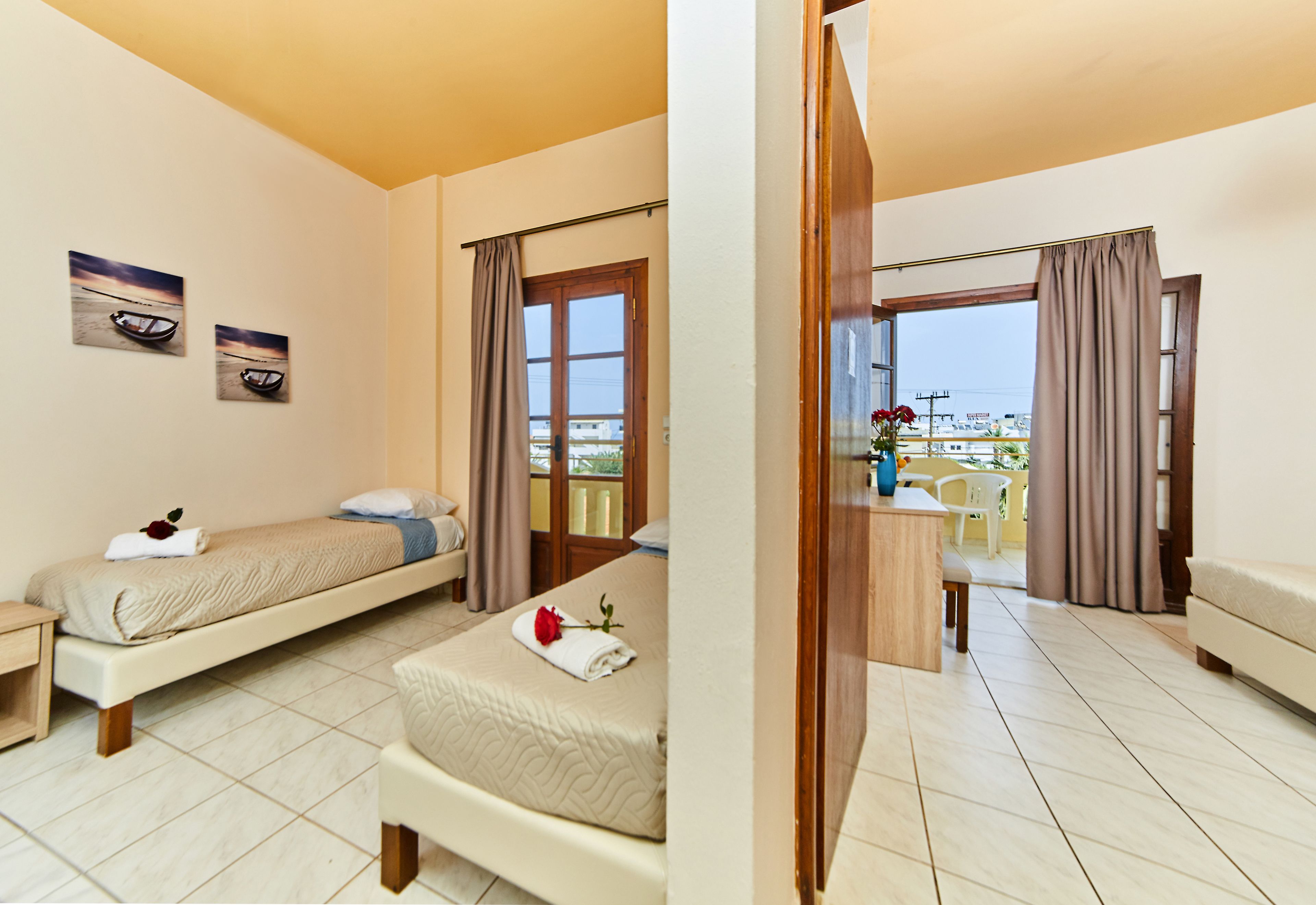 A hotel room with a bed, a desk, a chair, and a balcony with a view.