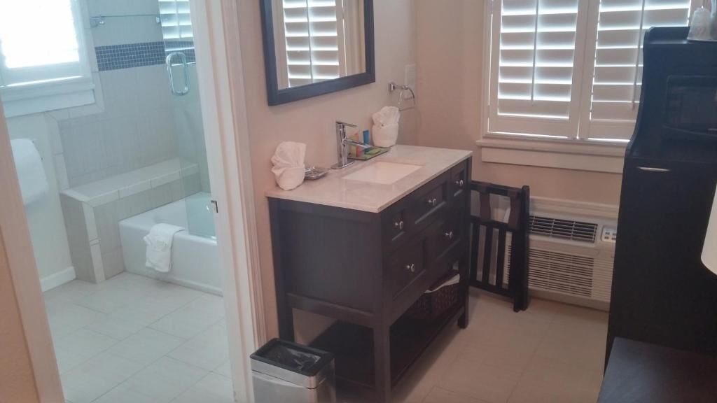 A bathroom with a white toilet, a dark vanity with a mirror, and a shower area.