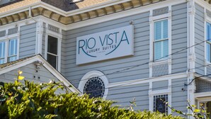 A building with a sign that reads "RIO VISTA LUXURY SUITES" indicating a hotel or resort. - Rio Vista Suites (Santa Cruz)