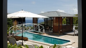 A pool area with lounge chairs, umbrellas, and a gazebo. - Spring Hotel Bequia (Bequia Island)