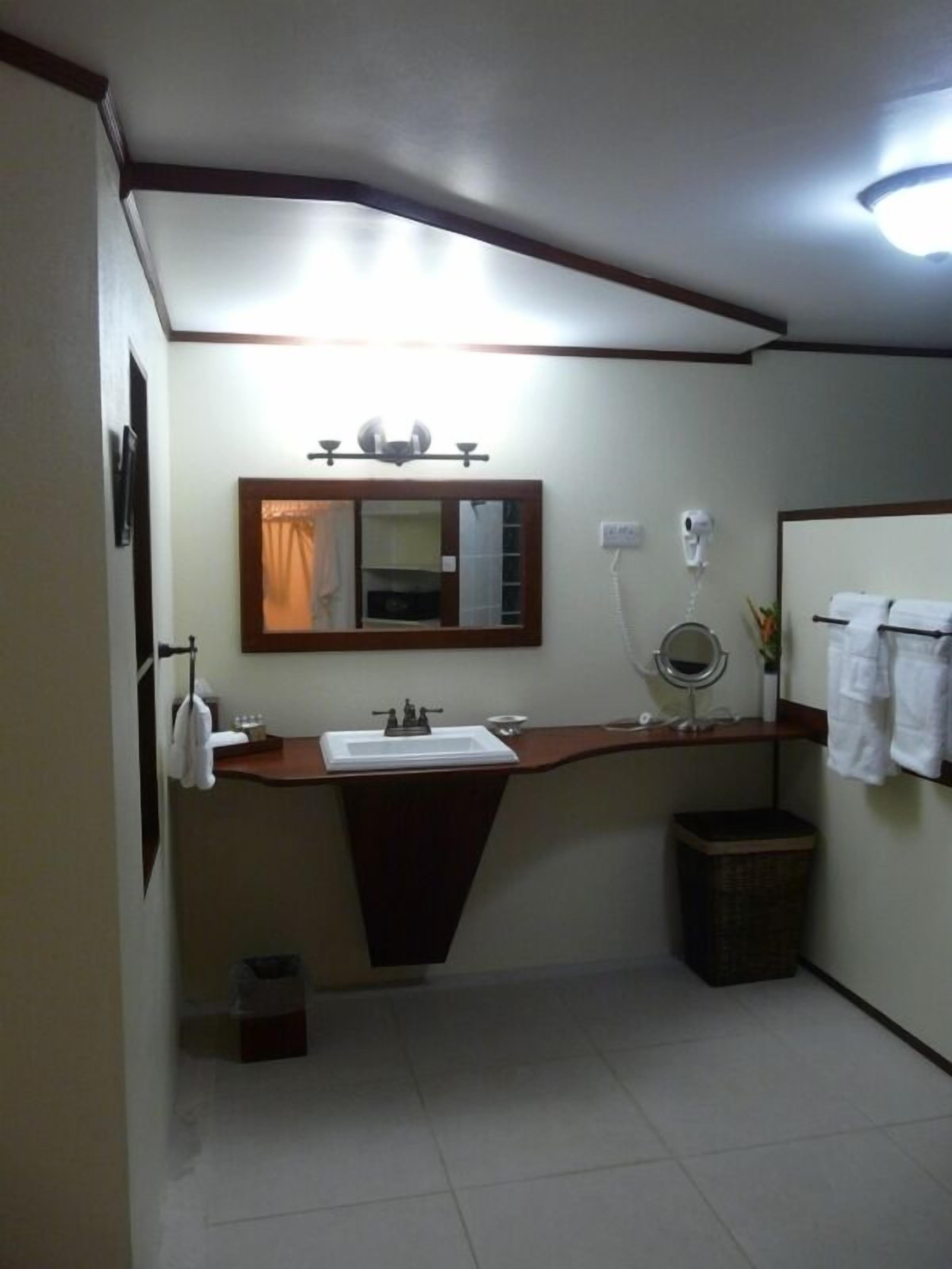 A bathroom with a sink, mirror, and towel rack.