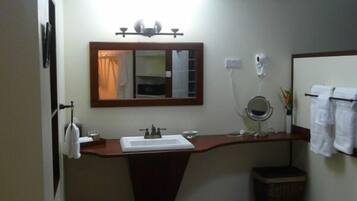 A bathroom with a sink, mirror, and towel rack.