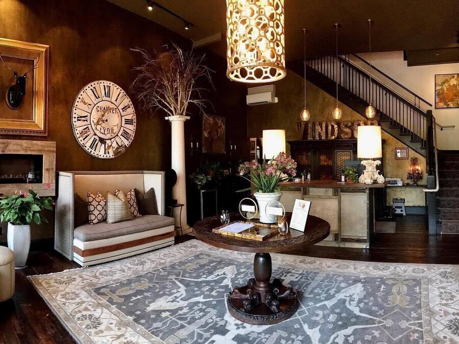 A spacious living area with a sofa, a coffee table, and a fireplace. There is a staircase leading to another level.